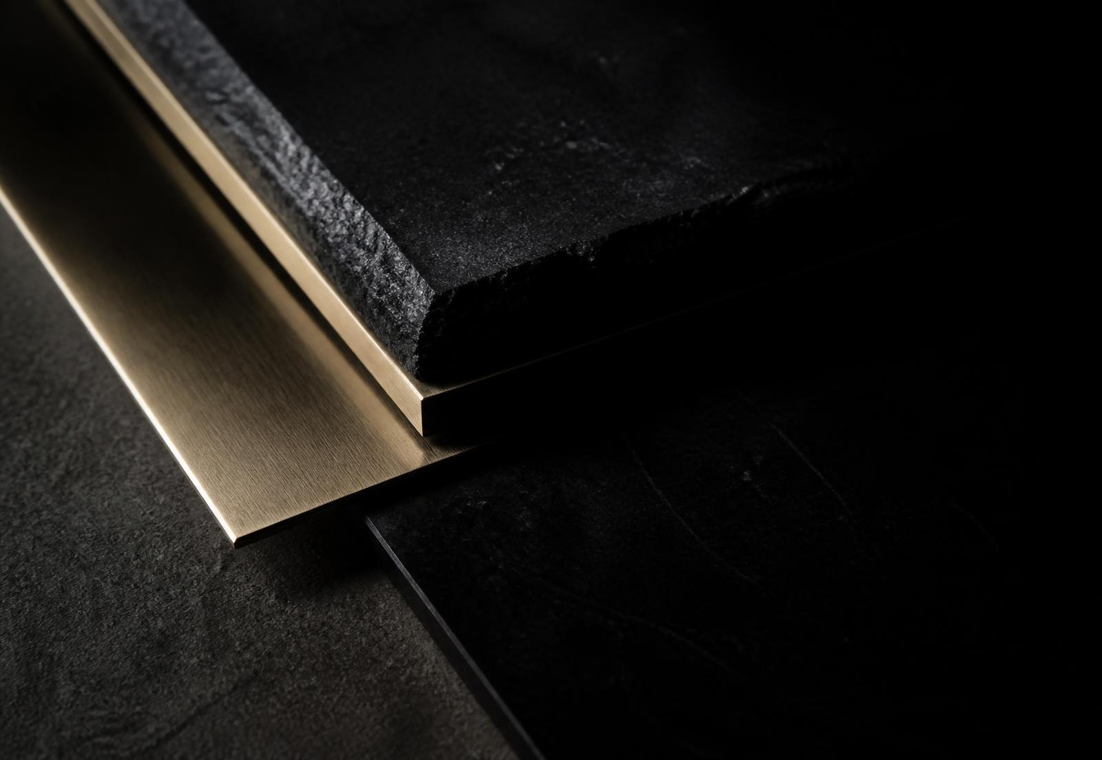 Close study of dark stone and brushed brass material samples